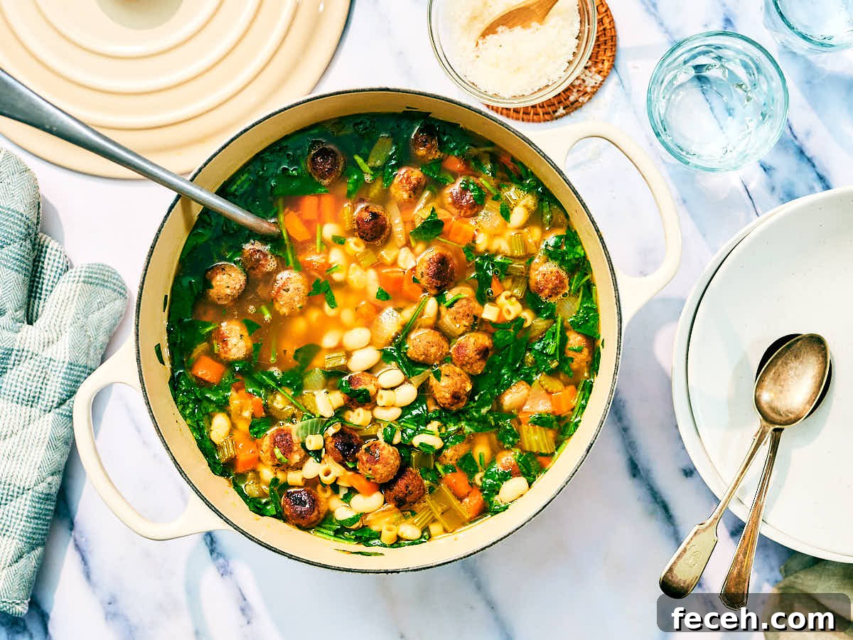 Vegan Italian Wedding Soup Recipe with Plant-Based Meatballs 3 Vegan Italian Wedding Soup in a pot with a serving spoon and bowls.