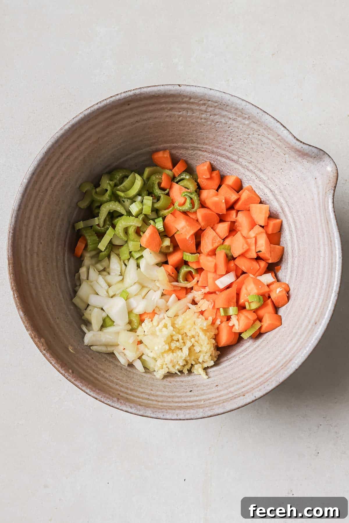 Instant Pot Navy Bean Soup Recipe for Creamy, Hearty Comfort 6 Chopped carrots, celery, onions, and garlic in a bowl, ingredients prepared for cooking.
