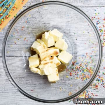 Butter and vanilla extract in glass bowl.