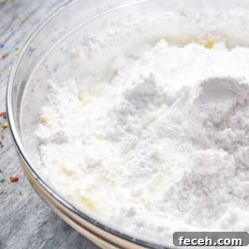 Milk added to other ingredients in glass bowl.