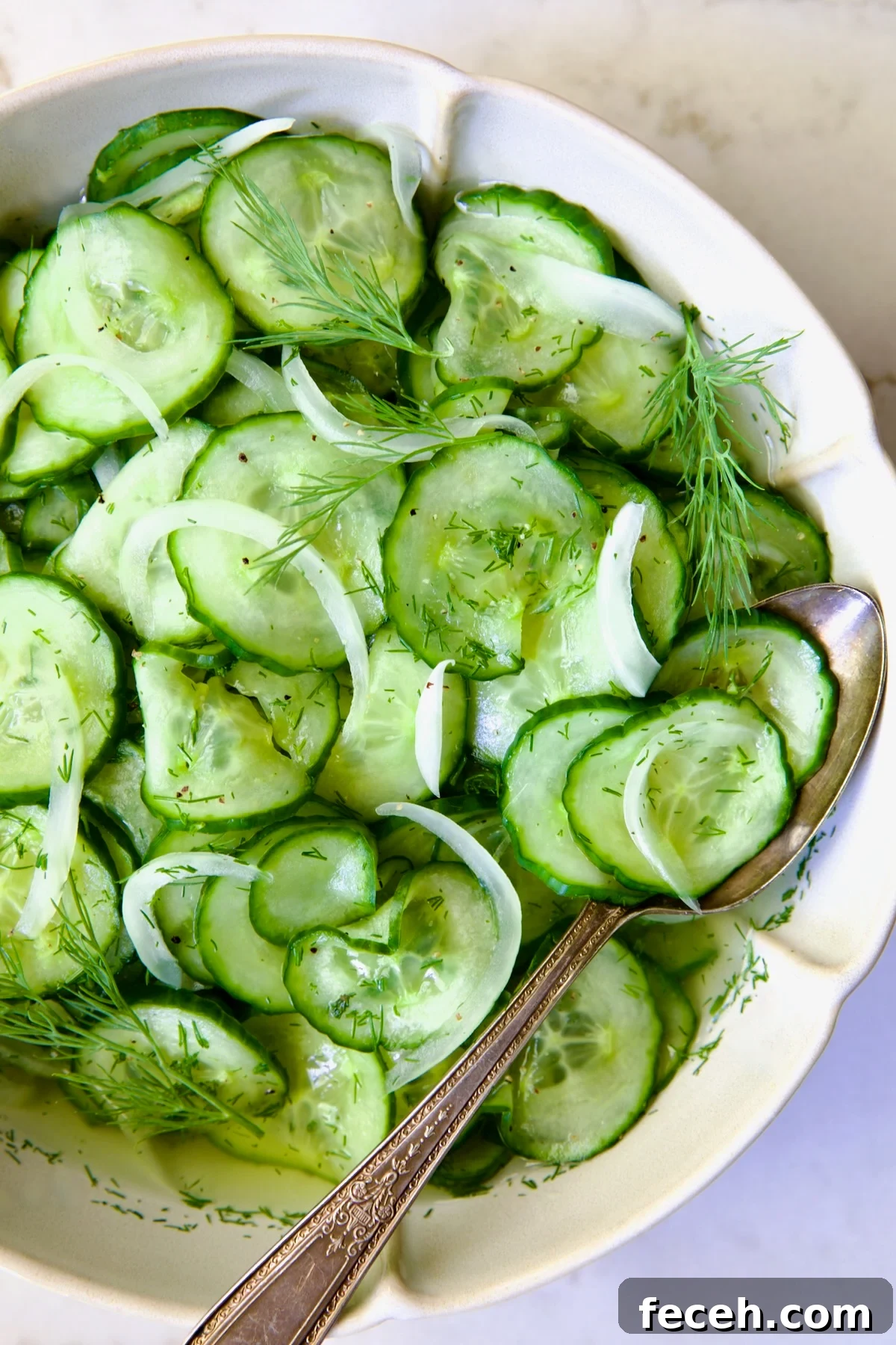 Cucumber Onion Salad in serving bowl with serving spoon.