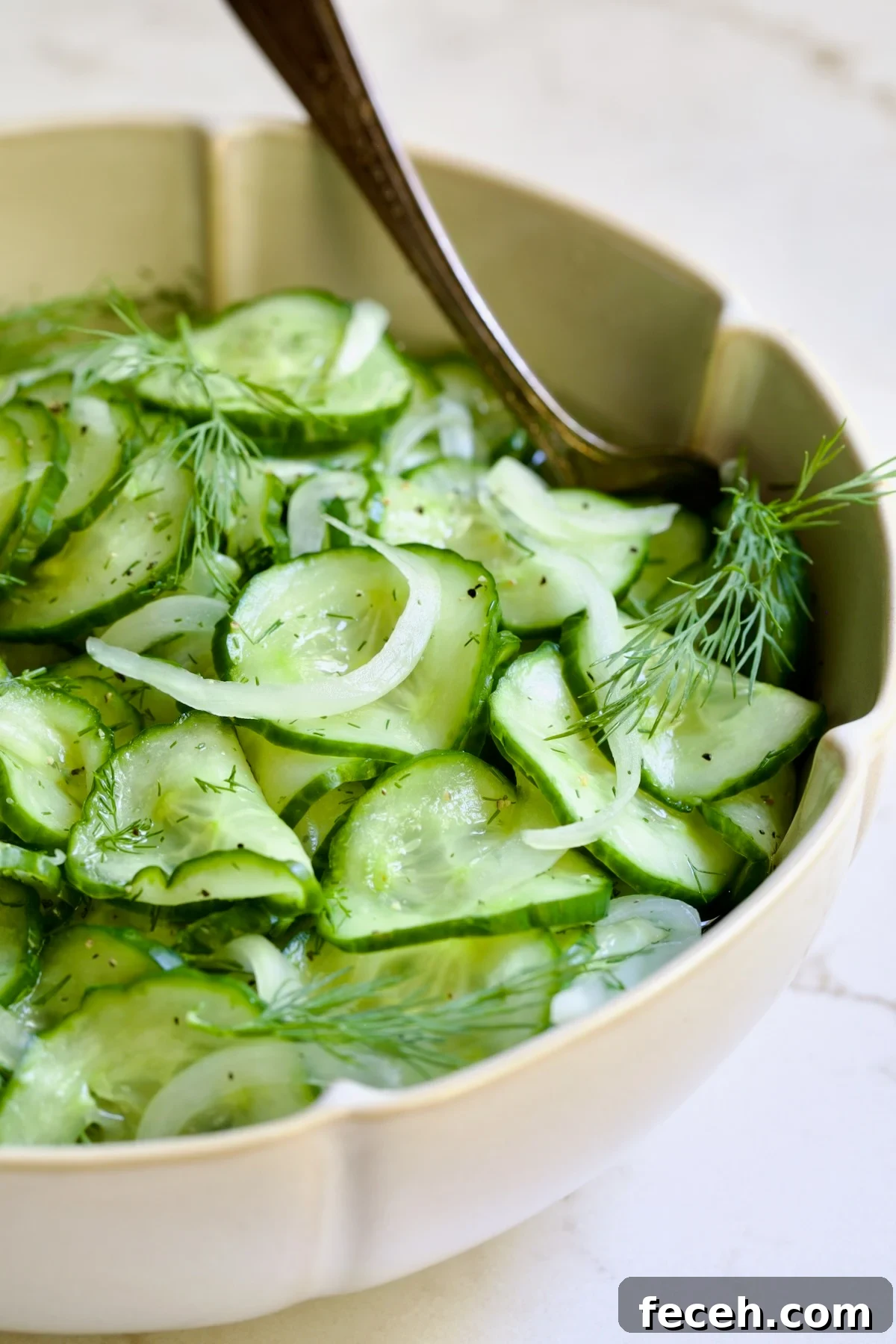 Cucumber Onion Salad in serving bowl with serving spoon.