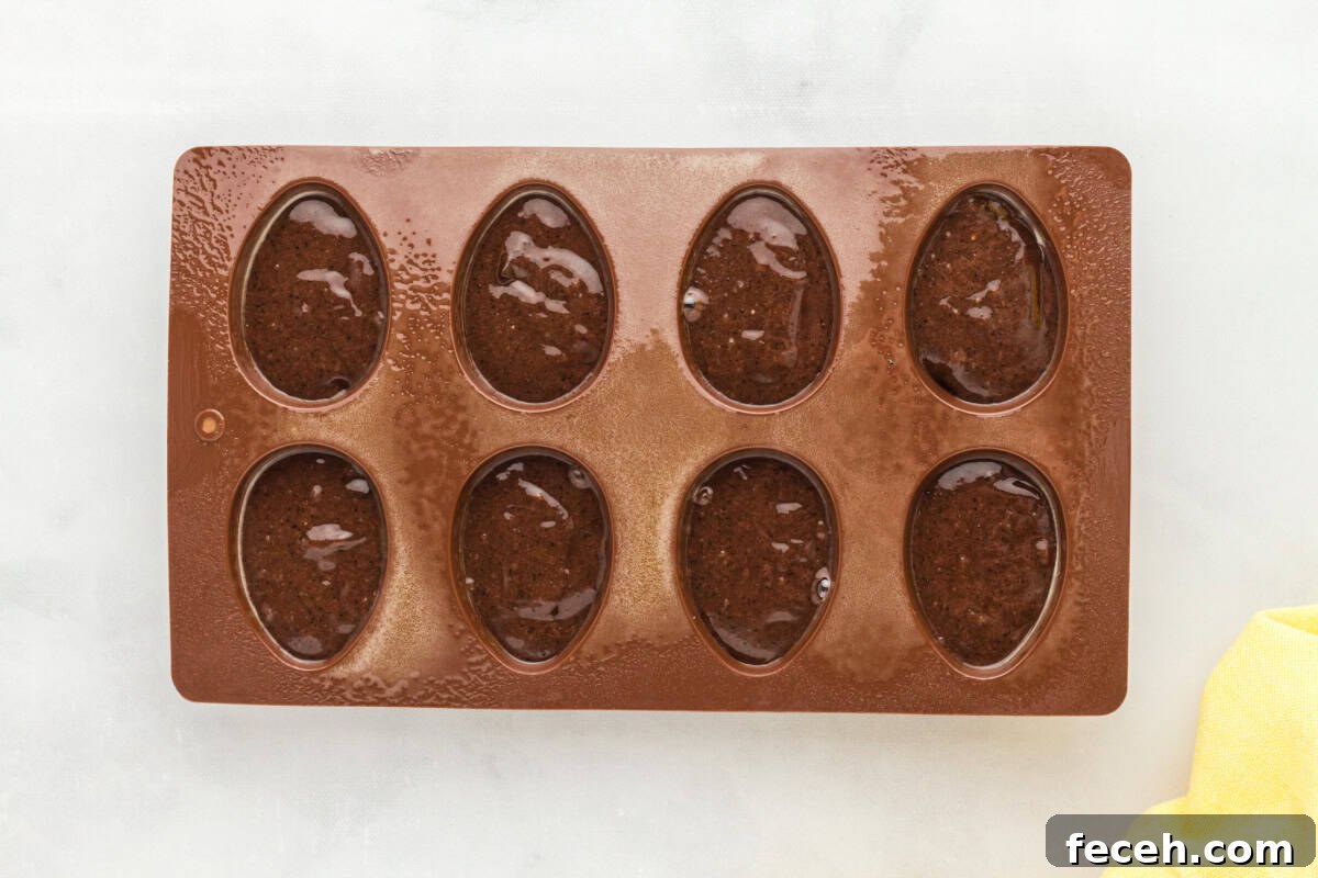 egg-shaped silicone mold filled with brownie batter.