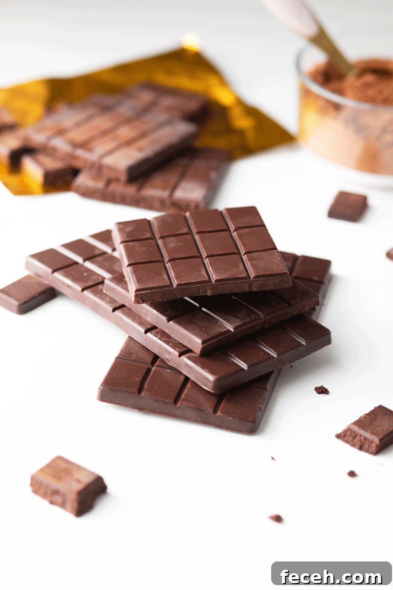 Homemade Dark Chocolate Bar Recipe: Rich, Smooth, & Simple 2 A stack of homemade chocolate bars with cocoa powder and a gold foil wrapper in the background