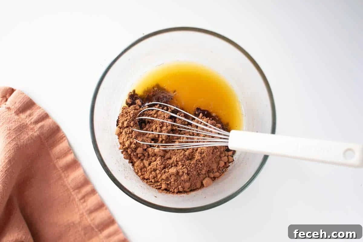 Homemade Dark Chocolate Bar Recipe: Rich, Smooth, & Simple 5 A bowl with melted cacao butter and cocoa powder being whisked together
