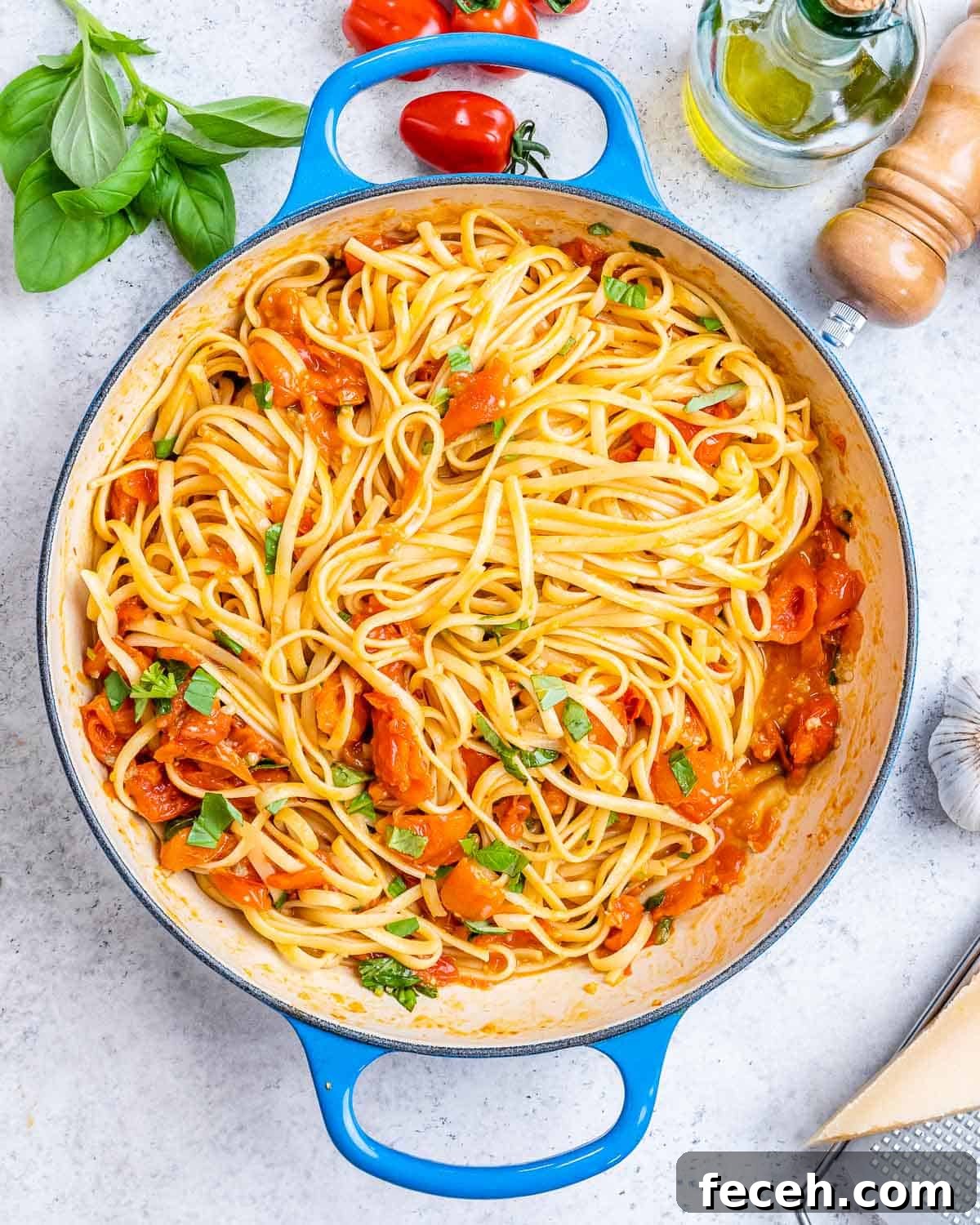 Cooked spaghetti in a strainer just after boiling, being lifted with tongs.