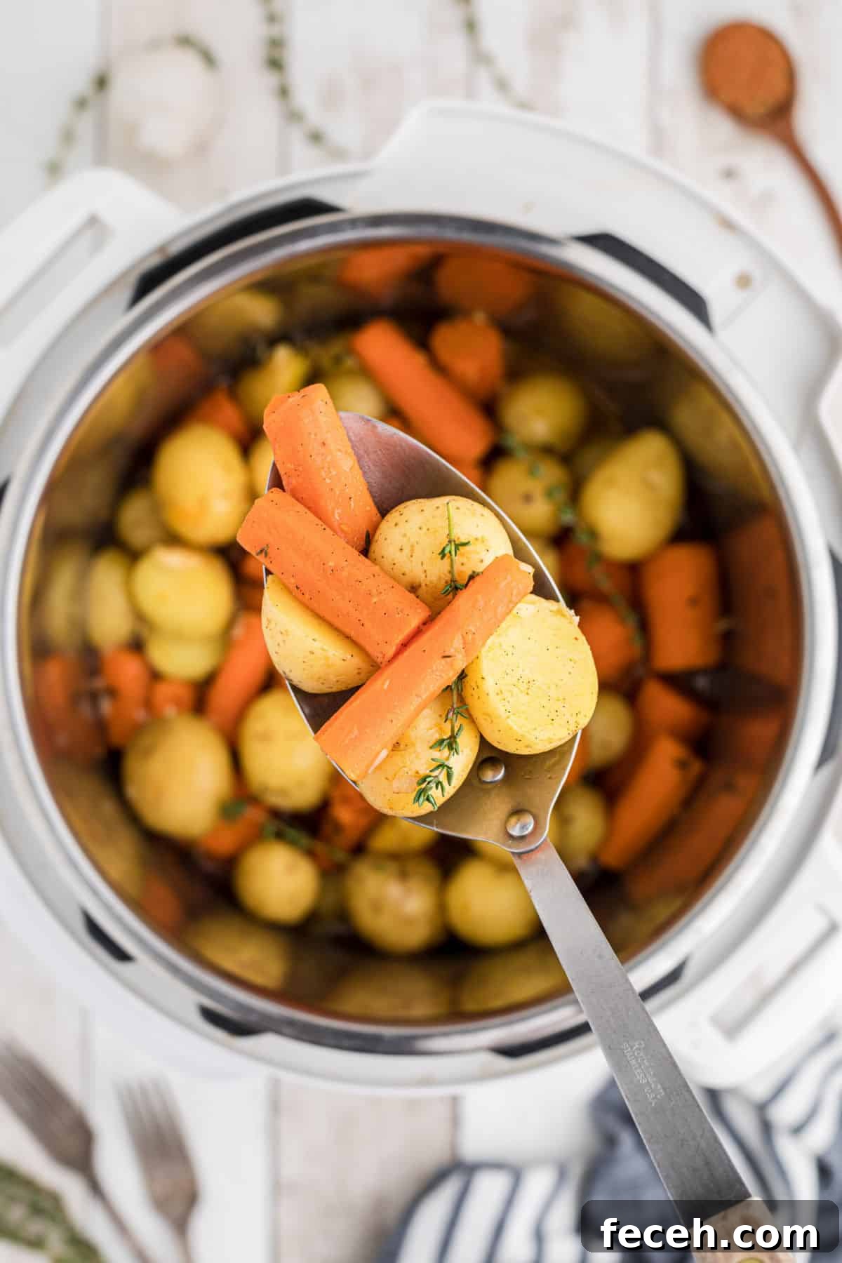 Overhead shot of an instant pot with potatoes and carrots with a spoon overhead dishing out.