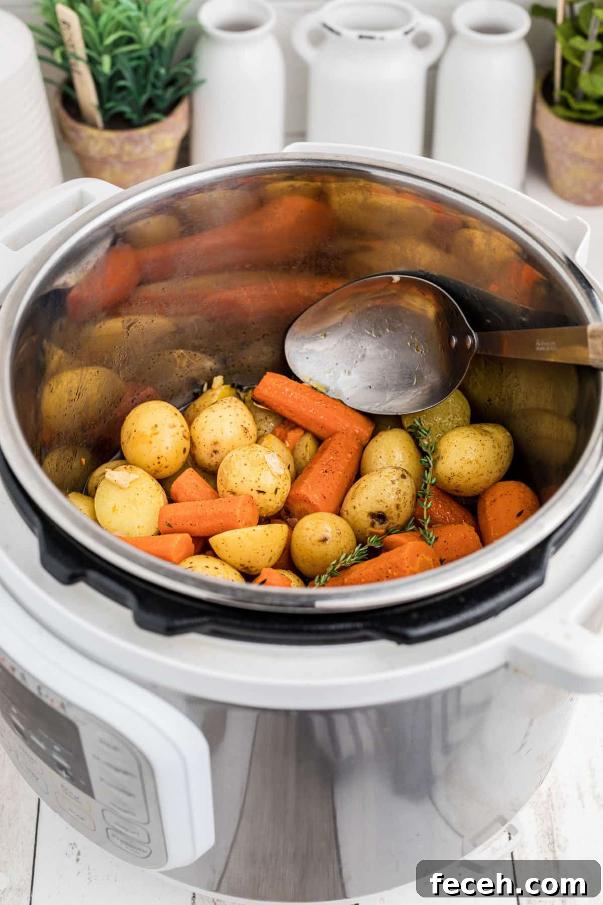 An instant pot potatoes and carrots recipe with a spoon digging in.