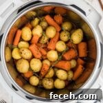 Close up overhead of an instant pot with potatoes and carrots.