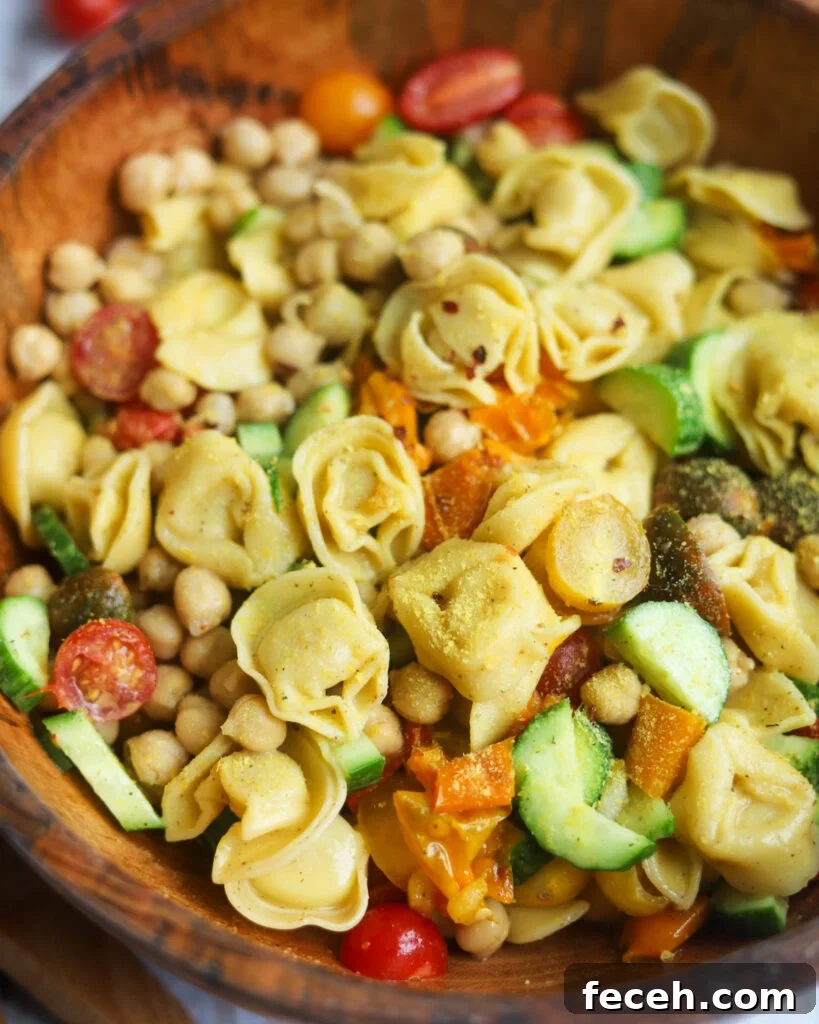 overhead view of a wooden serving bowl with vegan tortellini pasta salad.