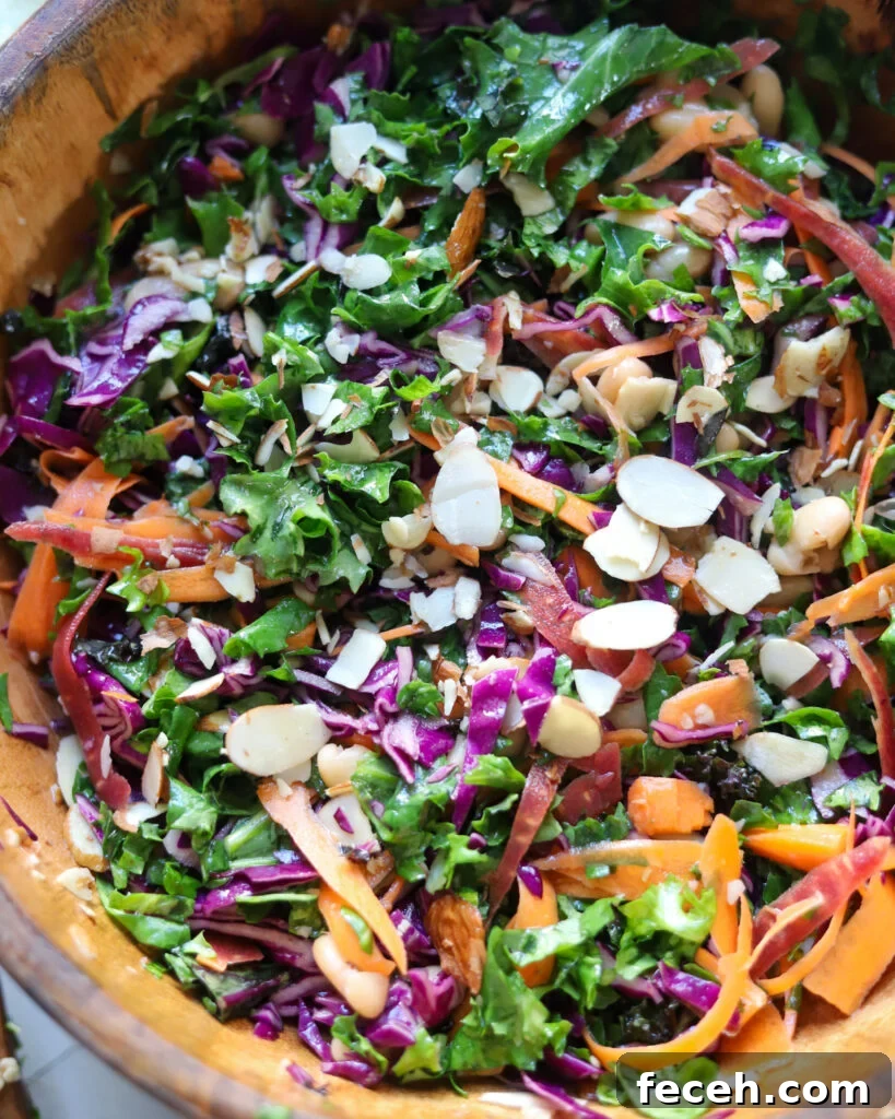 the best kale crunch salad with almonds and carrots in a wooden serving bowl.