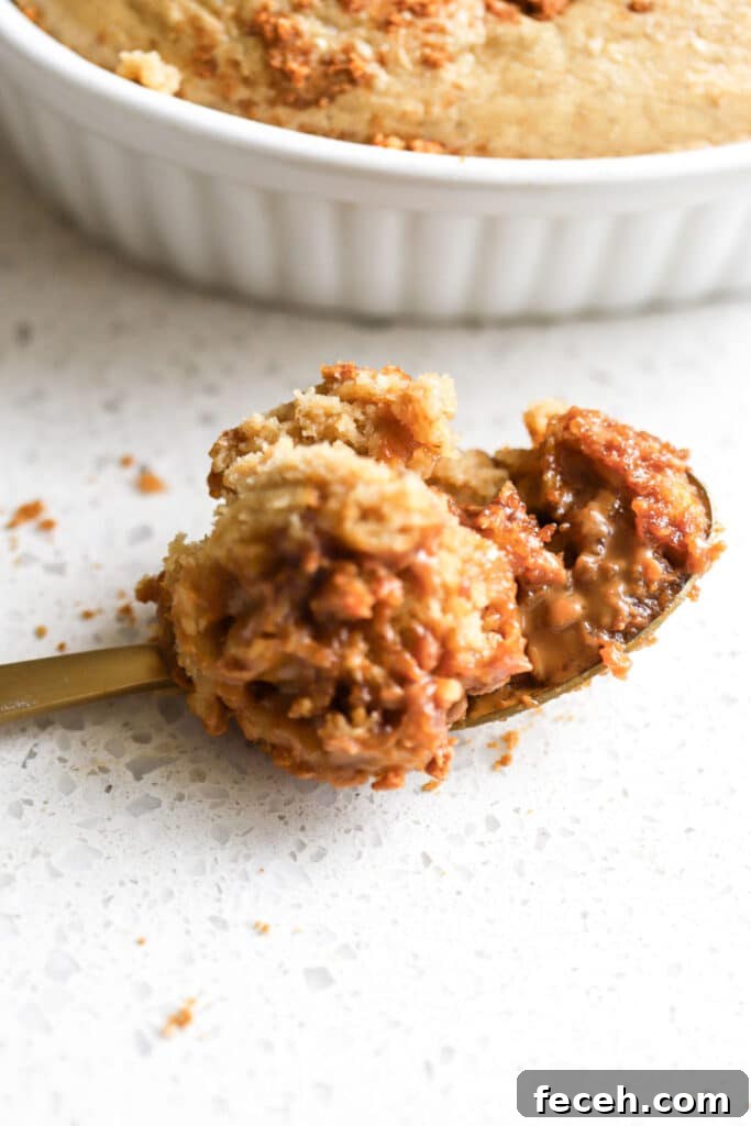 spoonful of biscoff baked oats next to white ramekin with cookie butter