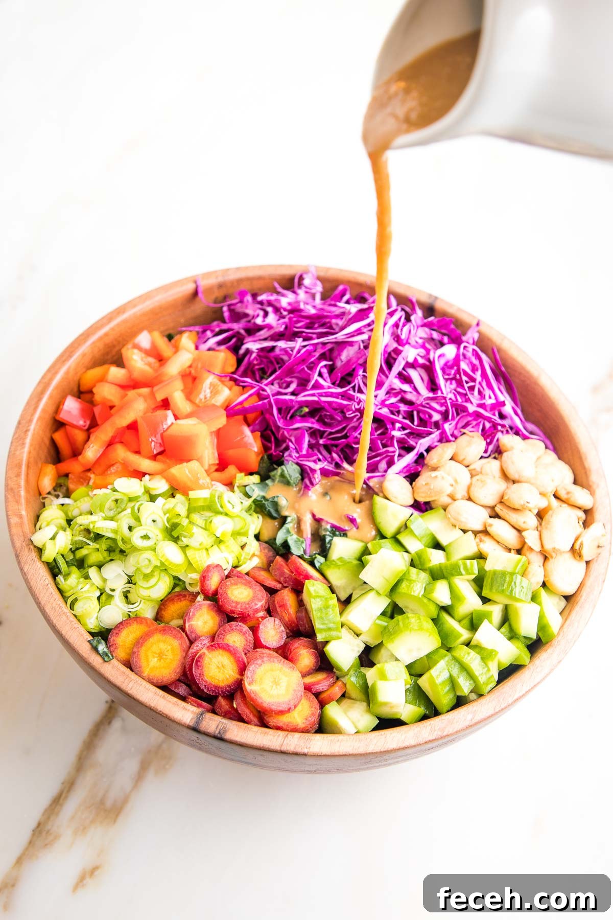 Dressing pour over colorful sections of chopped veggies.