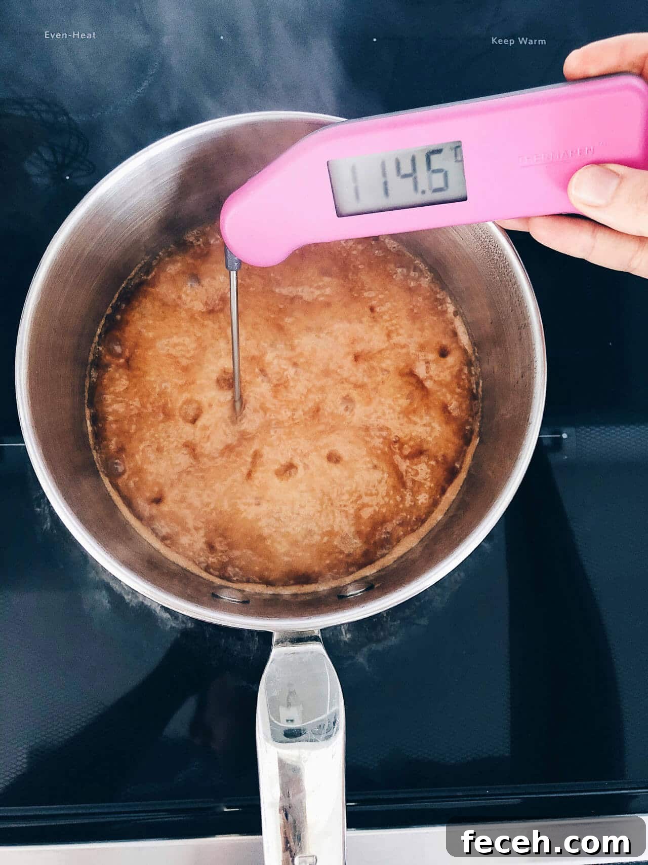 Checking the temperature of boiling caramel with an instant read thermometer