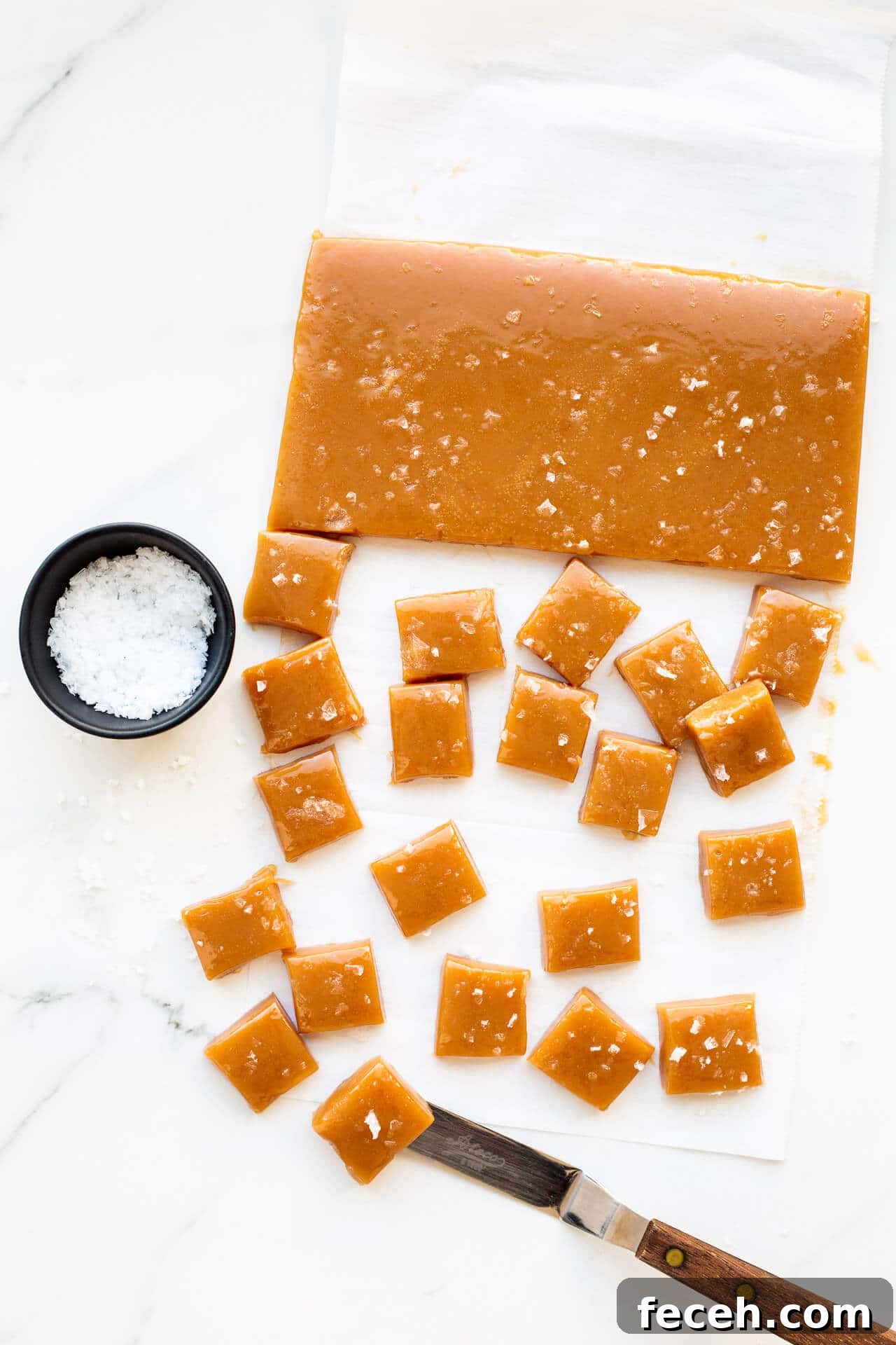 Cutting salted caramels into squares, garnishing with flaky sea salt