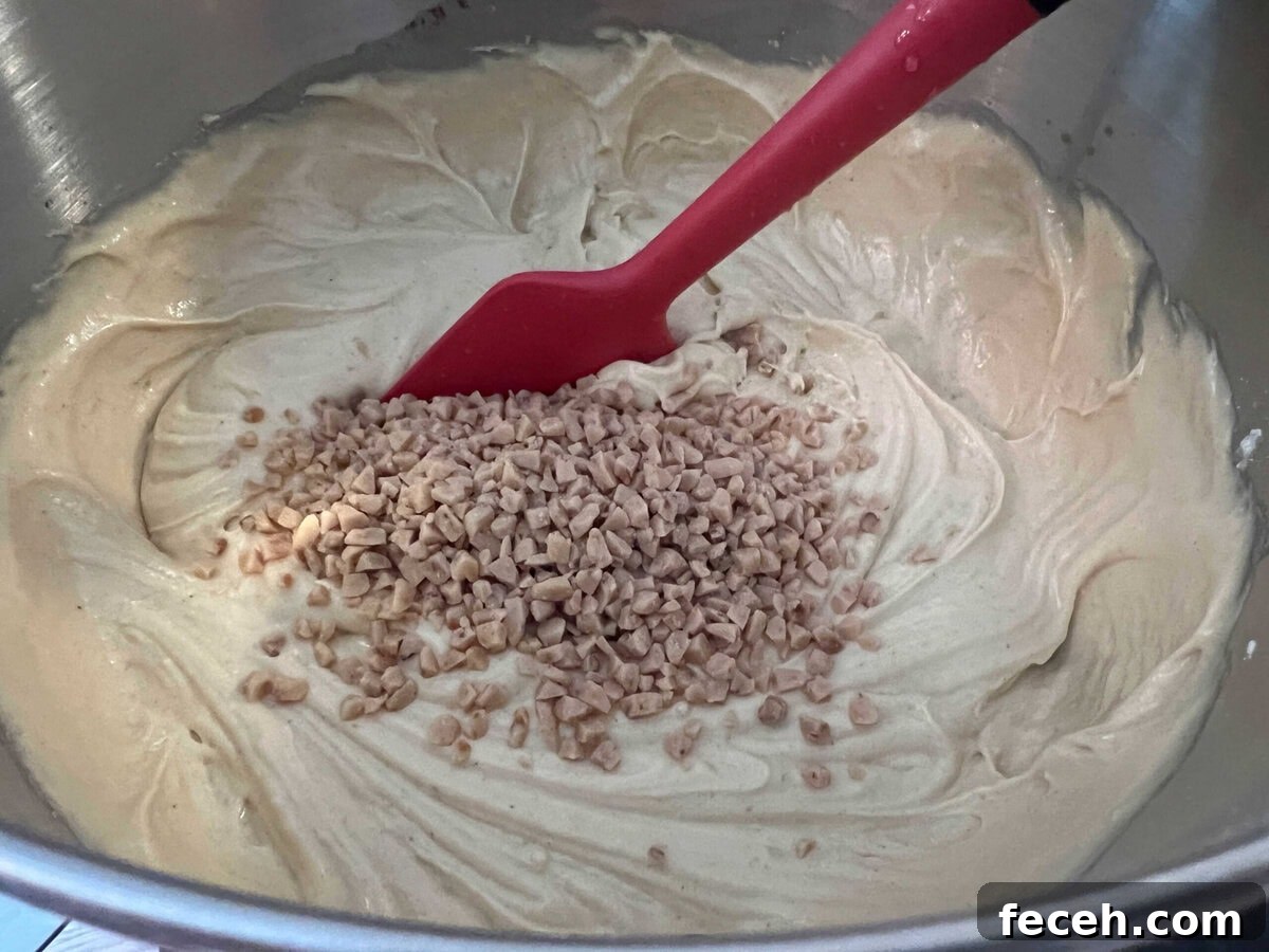Stirring toffee bits into the cake batter.