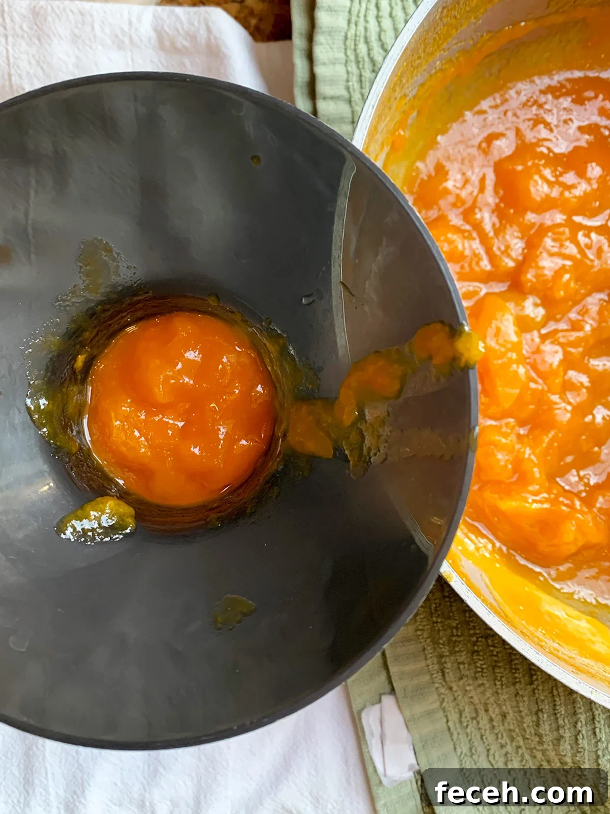 Ladling apricot preserves into jars with canning funnel.