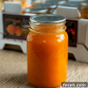Jar of apricot preserves in front of a produce box.