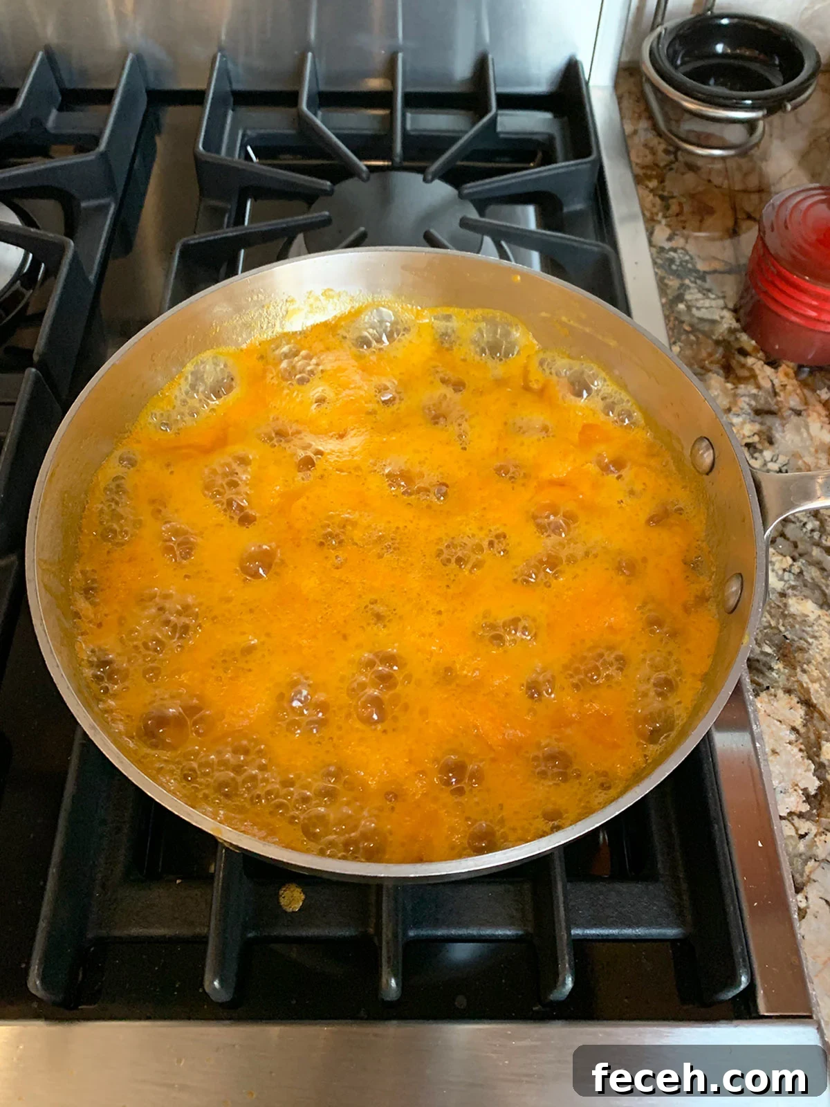 Apricot preserves in pot still boiling and foamy.