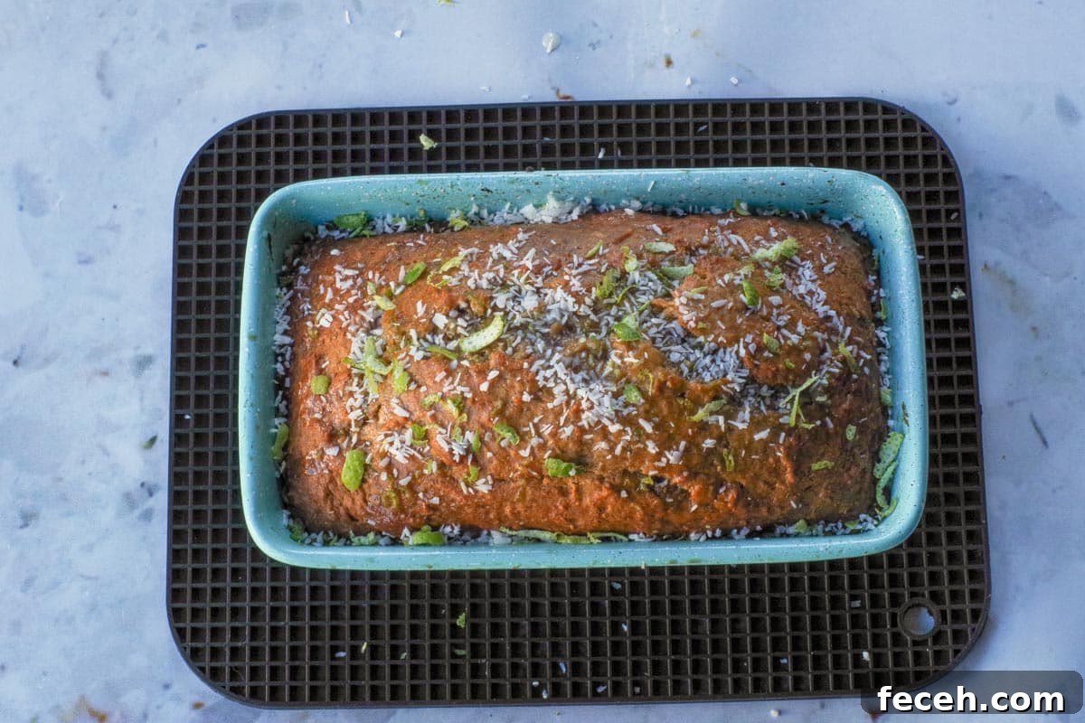 Tropical Banana Bread garnished with coconut and lime in loaf pan.