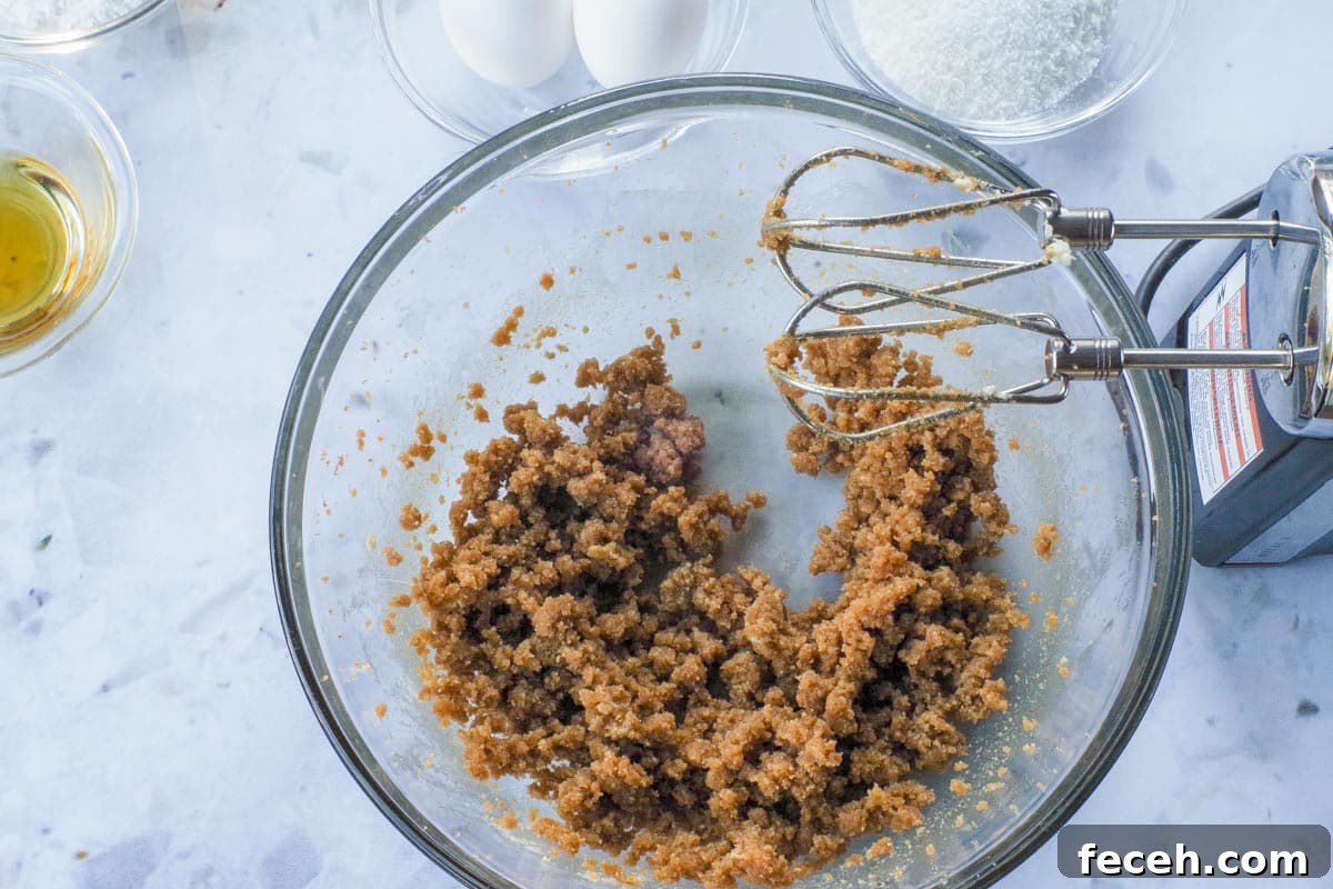 Brown sugar and butter mixed together in a glass bowl with electric mixer.