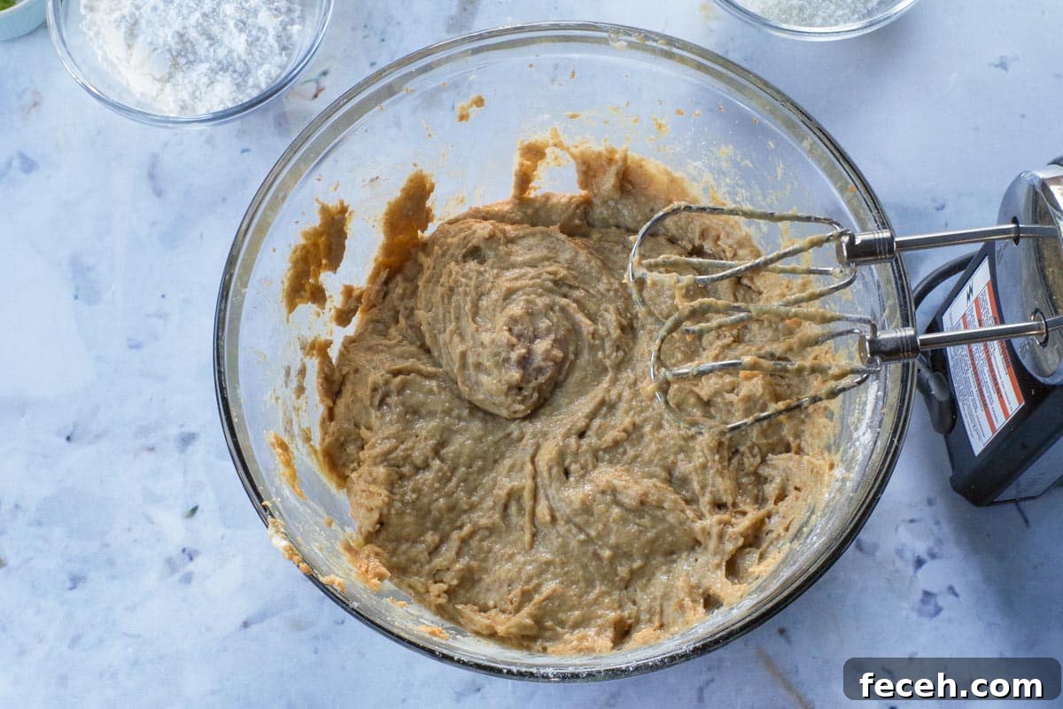 Dry ingredients beaten into wet mixture, in large glass bowl, with electric mixer.