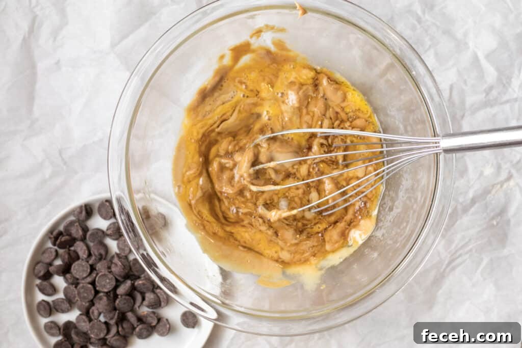 cookie batter in a bowl with chocolate chips next to it