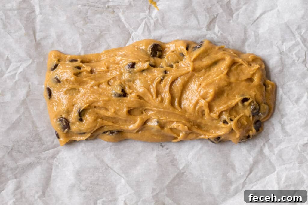 log of tahini cookie bar dough on parchment paper