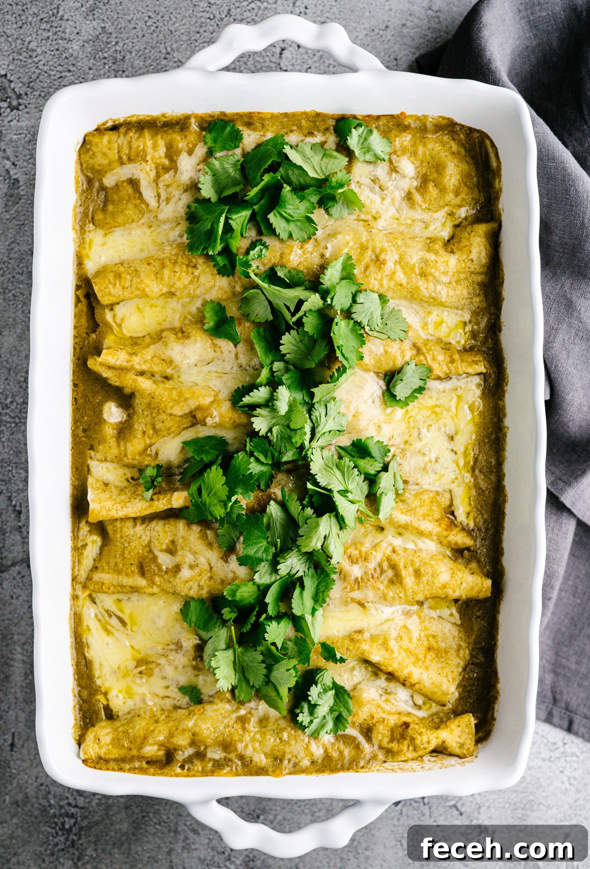 Pulled Pork Enchiladas served in a white ceramic baking dish photographed from above.