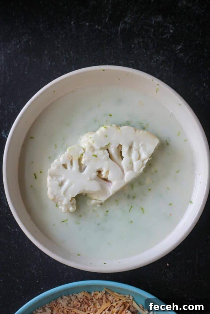 Slice of cauliflower dredged in the liquid coating.