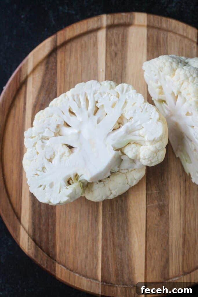 Half of a cauliflower on a cutting board.