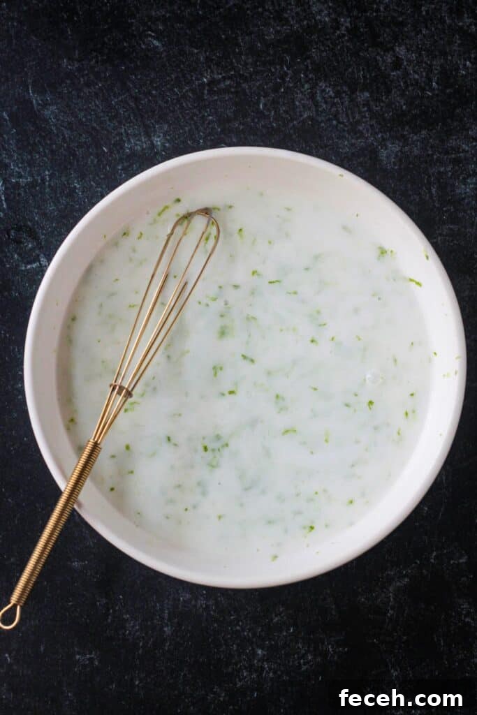 Liquid dredge ingredients whisked in a bowl.