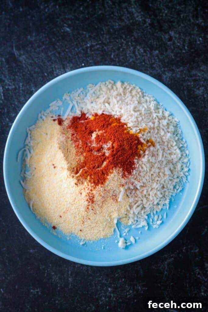 Cornmeal. breadcrumbs, shredded coconut, and spices in a bowl.