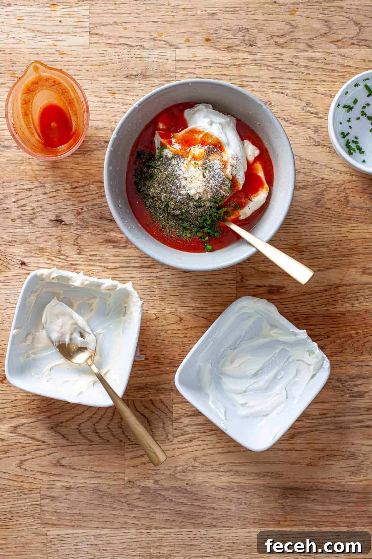 Ingredients for a homemade buffalo ranch sauce in a mixing bowl ready to get stirred by a spoon.
